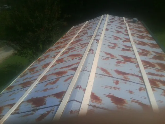 Rusted metal roof panels with new wood purlins before replacement — Storm Damage Roof Repair in Maple Valley by Roofing Brothers